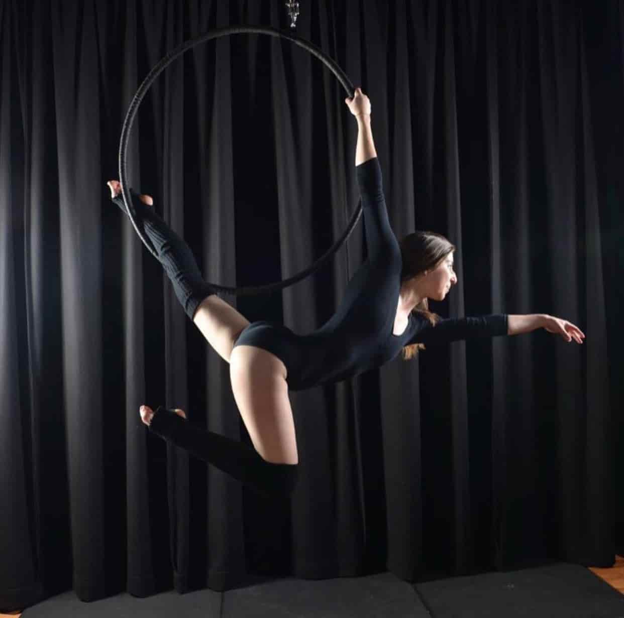 woman training aerial hoop for photoshoot wearing black, aerial silk classes, aerial silk, aerial fitness