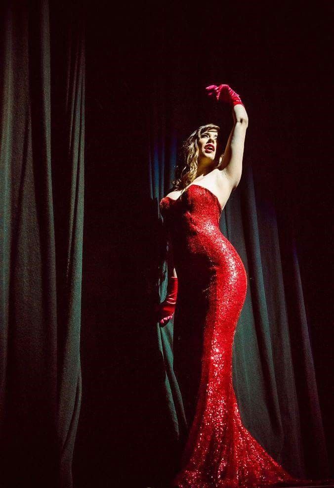 woman hostess mc on stage posing for camera in sequin red dress and gloves, pole fitness, pole dancing