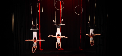 video image of circus routine on stage with 6 people doing doubles trapeze, aerial fitness, aerial silk classes