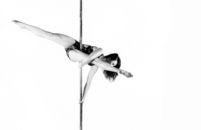 photo of woman pole dancing performing chopsticks trick during black and white photoshoot