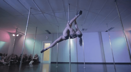 video image of woman performing on the pole in studio for students under blue lights