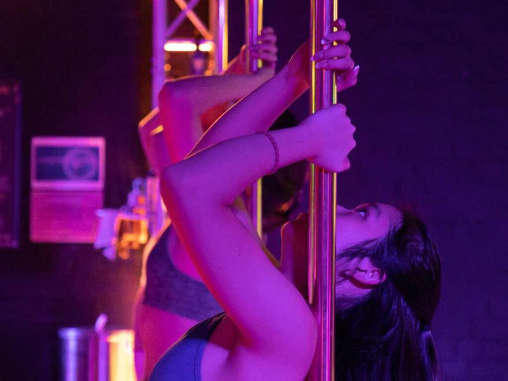 Pole dancer holding onto pole looking up at Melbourne CBD studio